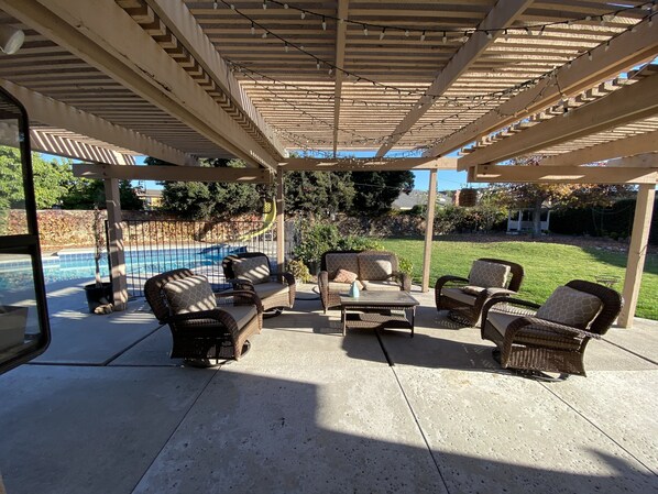 A covered patio with wicker furniture, a pool, and a view of the backyard. - Rare to find house of 5 BR and 4 Bath with big backyard in Fountain Valley.  (Fountain Valley)