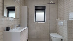 Appartement | Badkamer | Een douche, gratis toiletartikelen, een haardroger, handdoeken