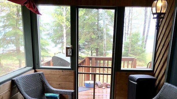 Un espacio al aire libre acogedor con mobiliario de mimbre y una terraza de madera.