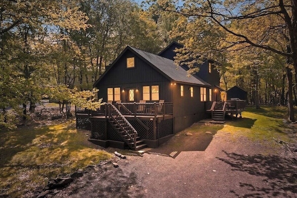 Eine Hütte mit einer Terrasse, Treppe und Veranda.