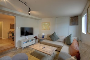 A living room with a flat-screen TV, a sofa, a coffee table, and a map on the wall. - 0651: Central Salida Home 5 Blocks to Dtwn & River (Salida)