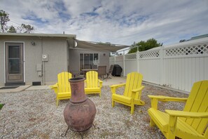 A backyard with a patio area, outdoor furniture, a large decorative pot, and a white fence. - 0651: Central Salida Home 5 Blocks to Dtwn & River (Salida)
