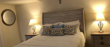 Cozy retreat with a large bed, bedside tables, and a wall-mounted cross, perfect for rest and relaxation.