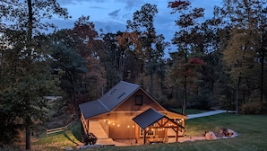 A rustic cabin with a metal roof, surrounded by a wooden deck and string lights. - Vista Getaway - Secluded country cabin, with wrap around porch and patio. (Klingerstown)