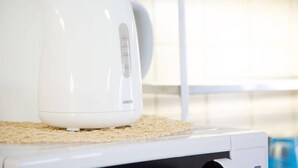 Una cafetera blanca sobre una encimera de cocina con un panel de control.