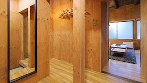Un intérieur en bois avec un miroir, un banc en bois et une petite table.