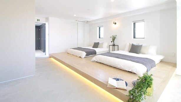 A modern hotel room with two beds, a small table, and a plant. - b hotel 902 Central Inner-Side Comfort Studio (Hiroshima City)