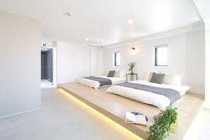 A modern hotel room with two beds, a small table, and a plant. - b hotel 902 Central Inner-Side Comfort Studio (Hiroshima City)