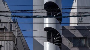 Un bâtiment moderne doté d’un escalier en colimaçon et d’une enseigne sur laquelle on peut lire « Hiroshi ».