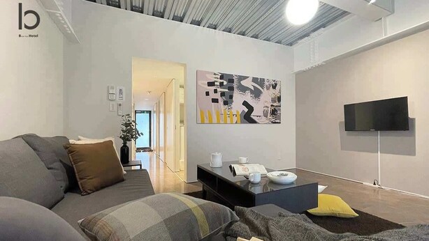 Une chambre d’hôtel moderne équipée d’un canapé, d’un téléviseur à écran plat et d’une table basse.