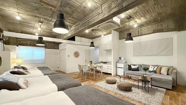 Un interior moderno con un dormitorio estilo loft, una zona de comedor y una cocina.