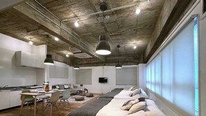 Un interior moderno con una cama grande, un comedor y una cocina.