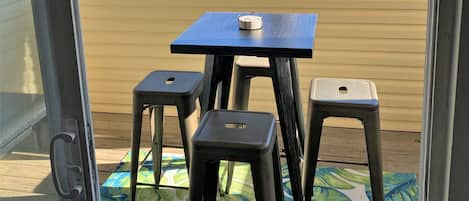 Een klein terras met een tafel en twee krukjes.
