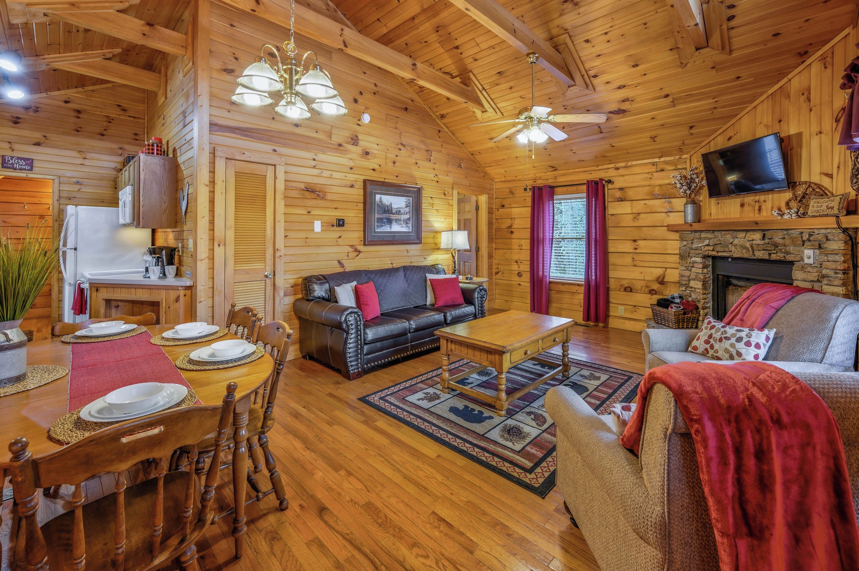 Interior acogedor de una cabaña de madera con comedor, sala de estar con chimenea y cocina.