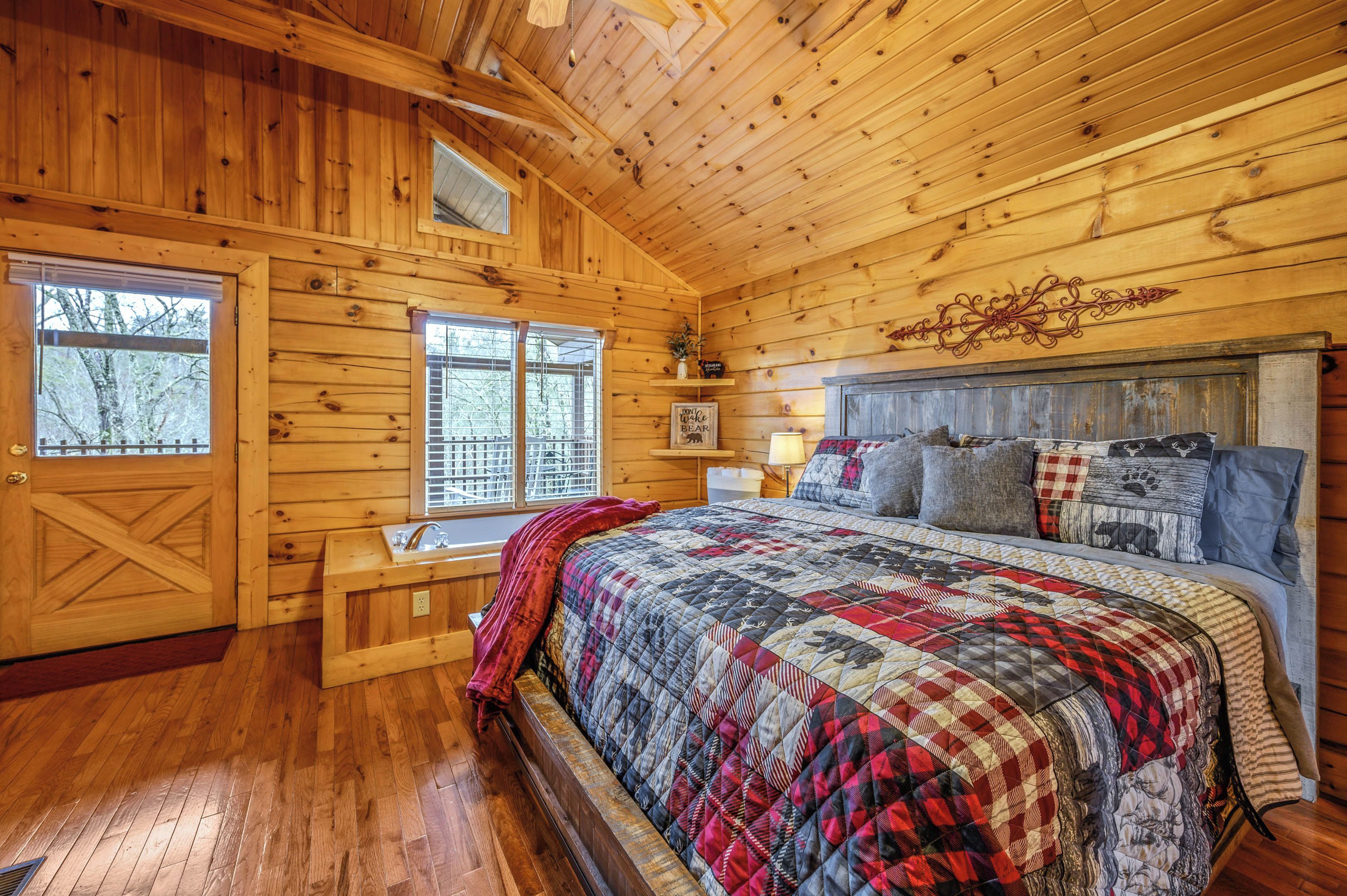 A wooden cabin bedroom with a large bed, a bench by the window, and a rustic decor.