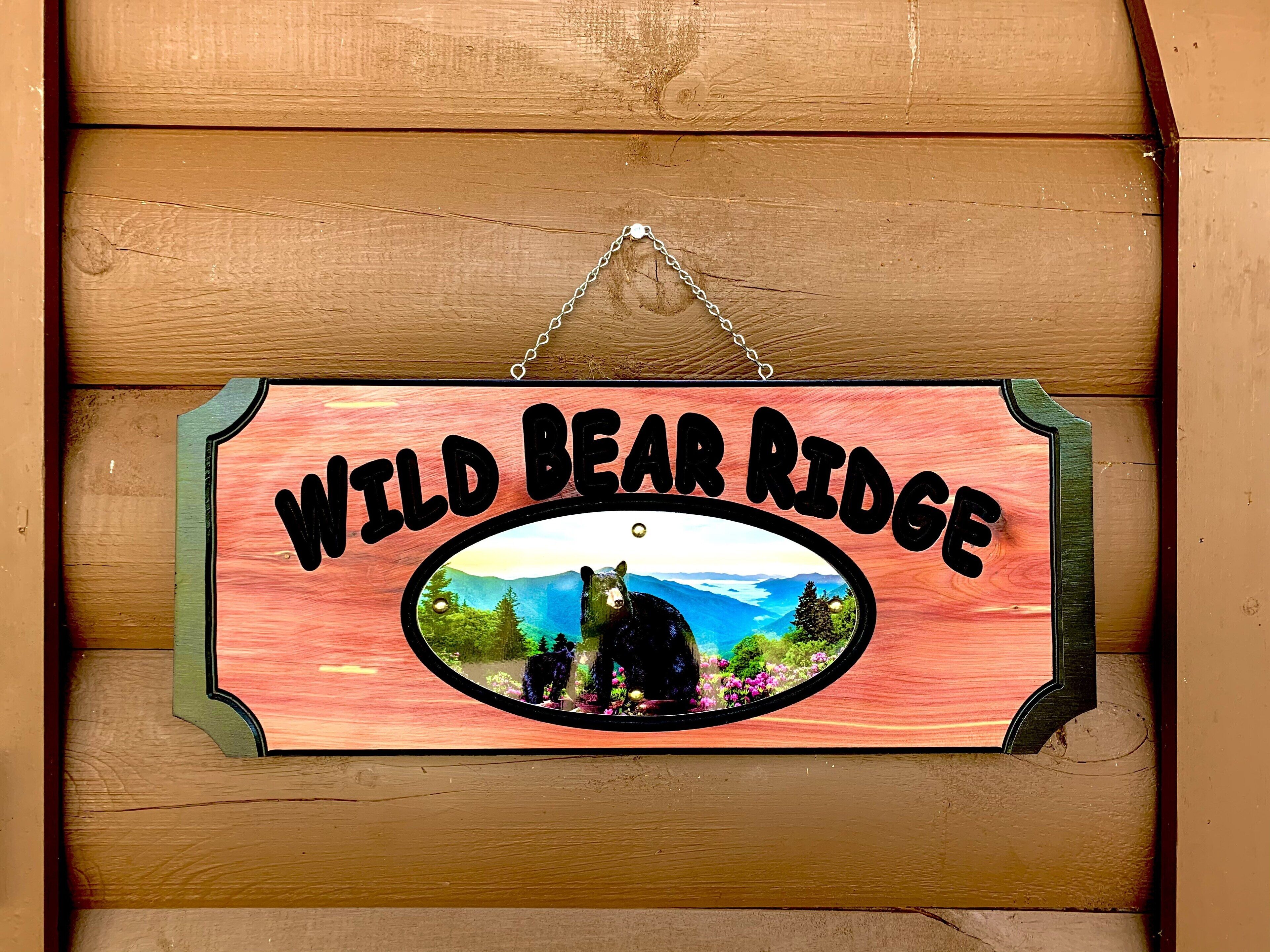 A wooden sign with a bear and mountains, labeled "Wild Bear Ridge."