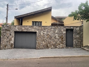 A building with a stone facade, two garage doors, and a flat roof.