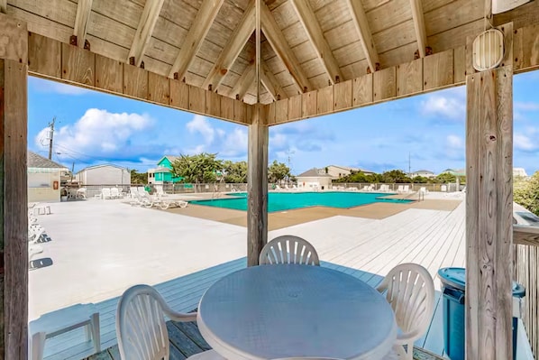 Relax by the pool with a view of the surrounding area from this outdoor space featuring a deck and lounge chairs.