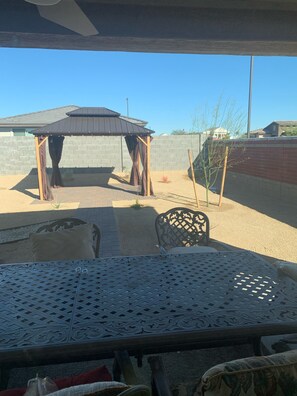 A patio area with a pergola, outdoor seating, and a view of the neighborhood.