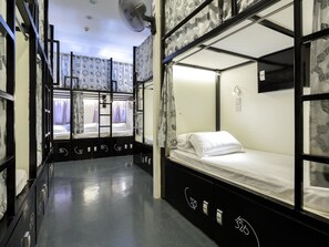 A dormitory-style room with bunk beds, numbered doors, and a ceiling fan. - K Space Inn Owen - Hostel (Singapore)