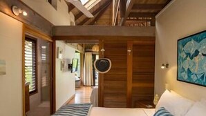 A bedroom with a bed, a bedside table, a mirror, and a painting on the wall. - Stay at 'Banfield 4' (Wongaling Beach)