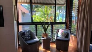 A room with two wicker chairs, a small table, and a window with blinds. - Stay at 'Banfield 4' (Wongaling Beach)