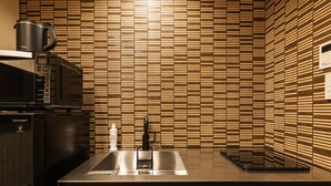 A modern kitchen with a microwave, coffee maker, and sink. - Grand Base Urakami (Nagasaki)