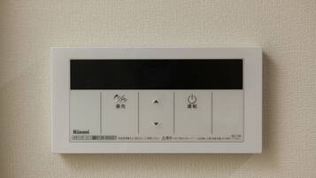 Een bedieningspaneel met Japanse tekst, een aan/uit-knop en een draaiknop voor temperatuurregeling.