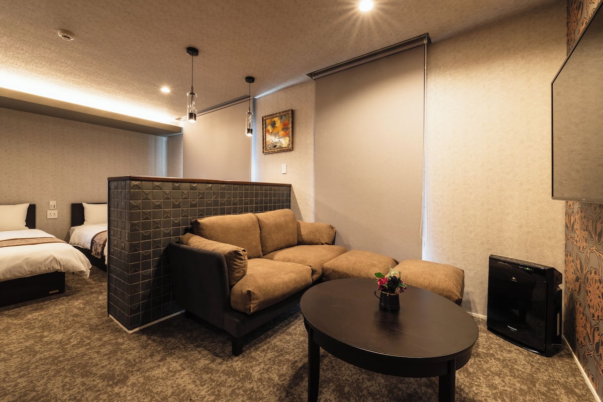 A cozy room with a sectional sofa, a small table, and a TV.