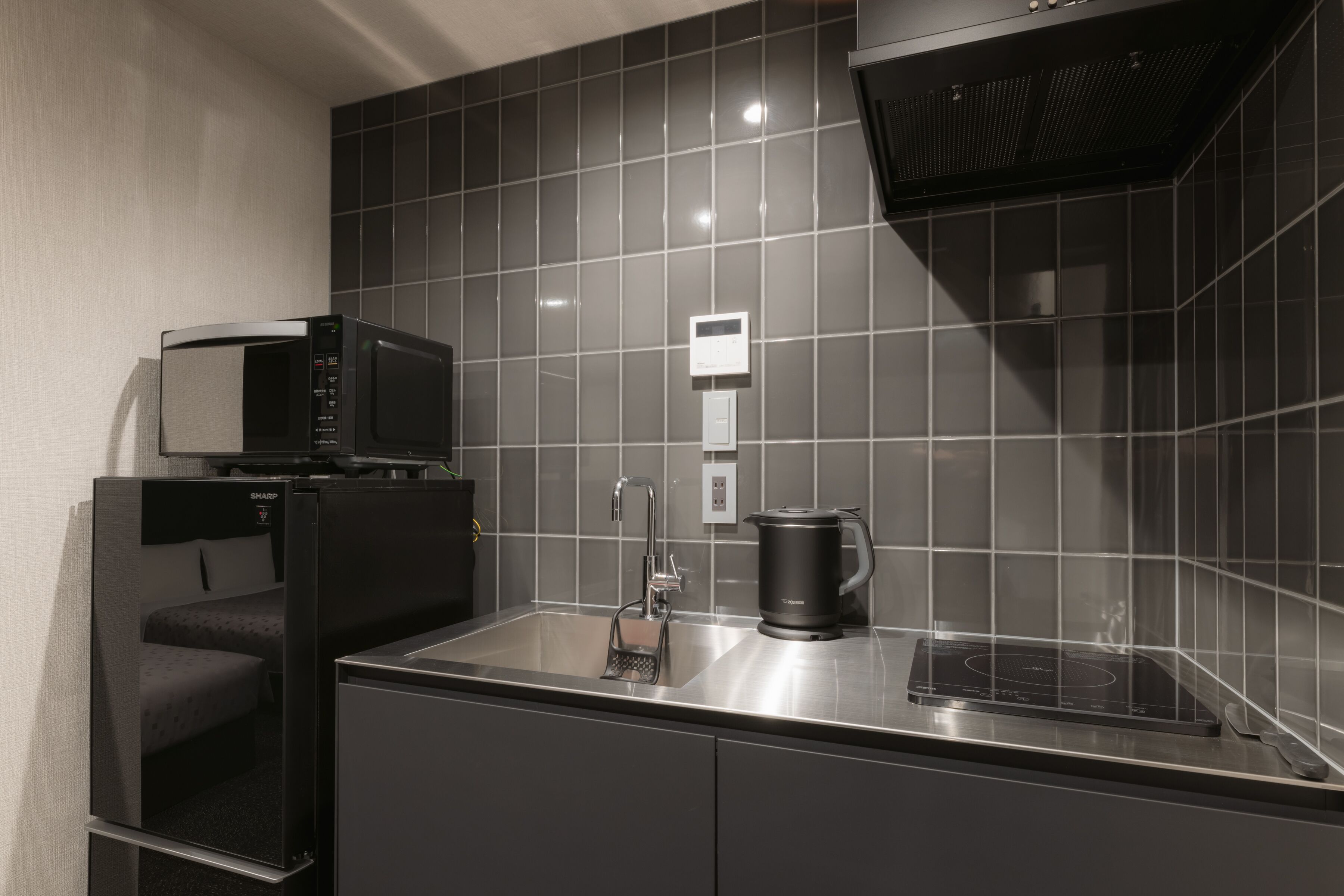 A modern kitchen with a microwave, kettle, and built-in oven.