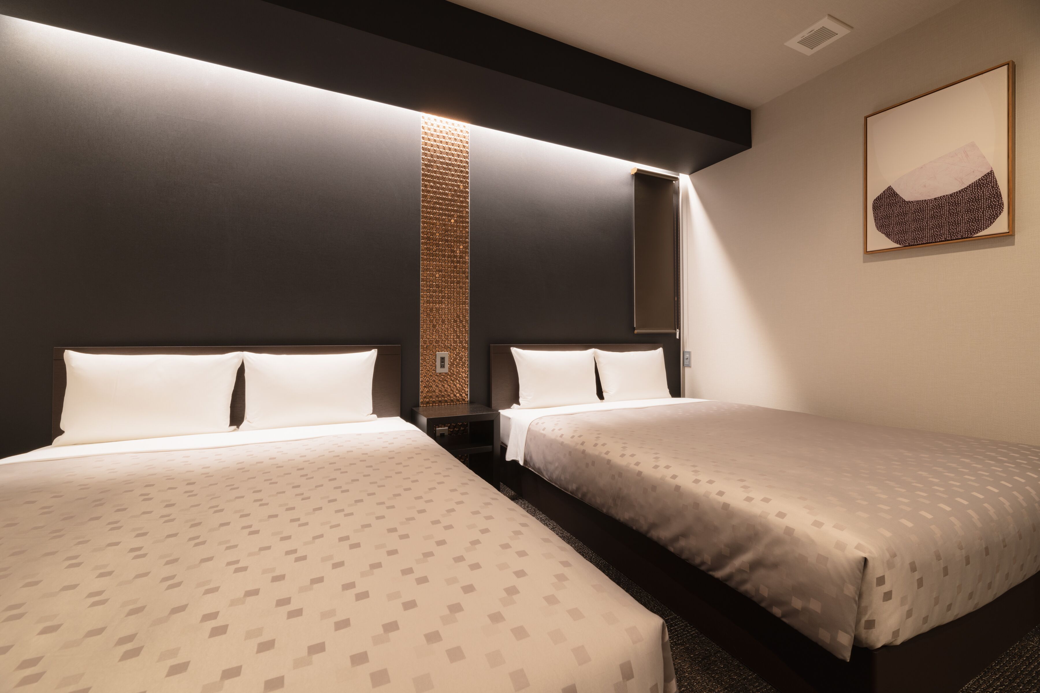 Une chambre d’hôtel avec deux lits, un grand miroir et une œuvre d’art accrochée au mur.
