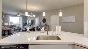 A modern kitchen with a central island, stainless steel sink, and pendant lighting. - Picture Perfect 2/2 with Views Galore! The Cays at Ocotillo! 30 Night Minimum Stay! (Chandler)