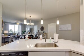 Enjoy meals in this spacious kitchen and dining area, featuring a large island, stainless steel sink, and dishwasher.