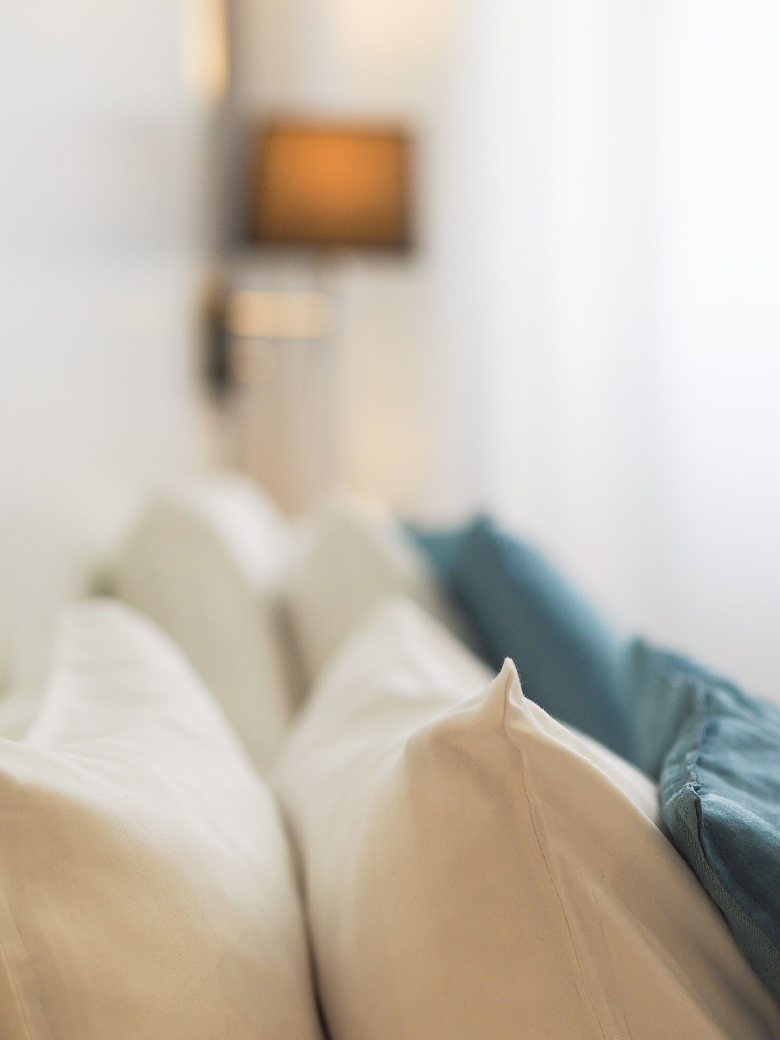 Una cama con ropa de cama blanca y azul.