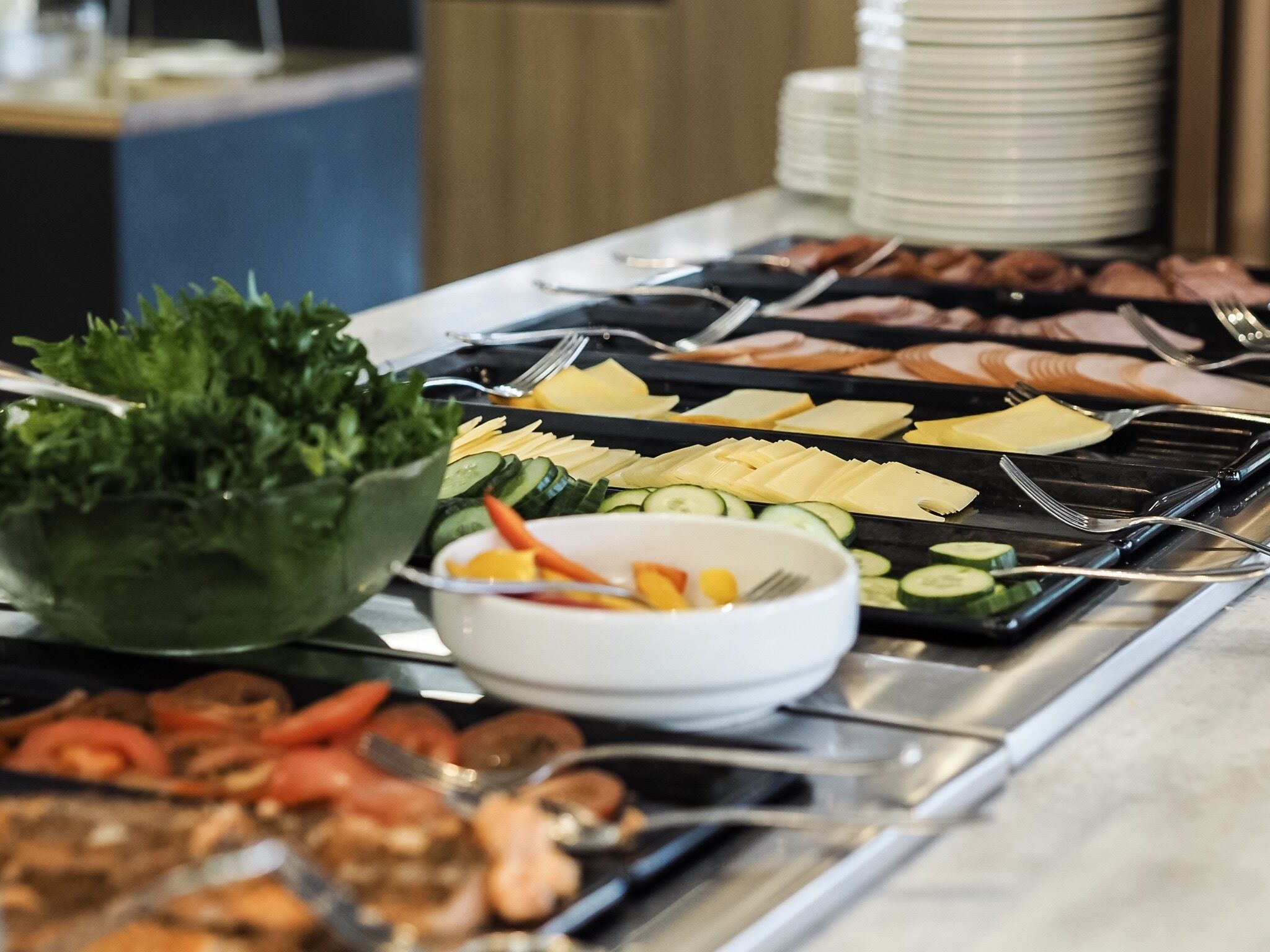 A buffet with various food options including meats, cheeses, and vegetables.