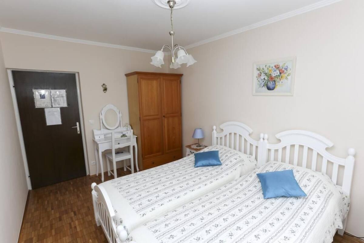 Ein Schlafzimmer mit Bett, Kommode, Schminktisch und einer Tür.