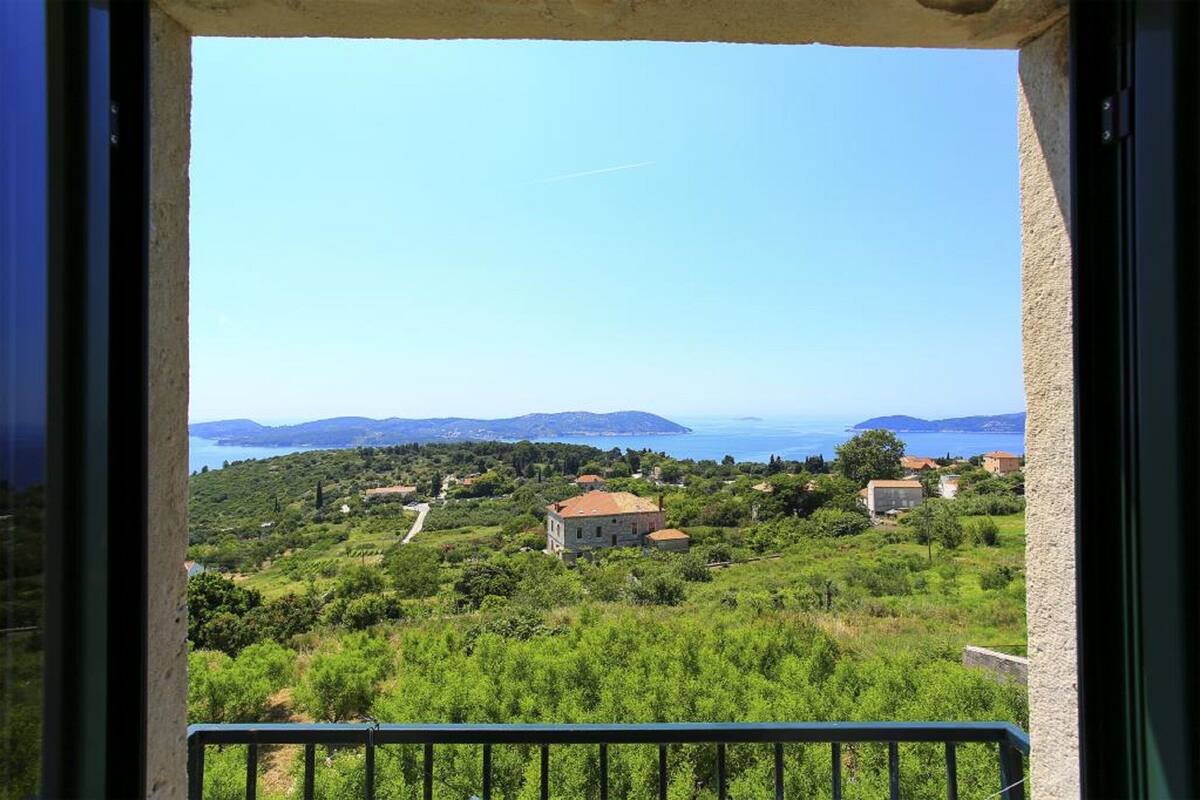 Ein Balkon mit Blick auf eine Küstenlandschaft, einschließlich Häuser und Grünflächen.