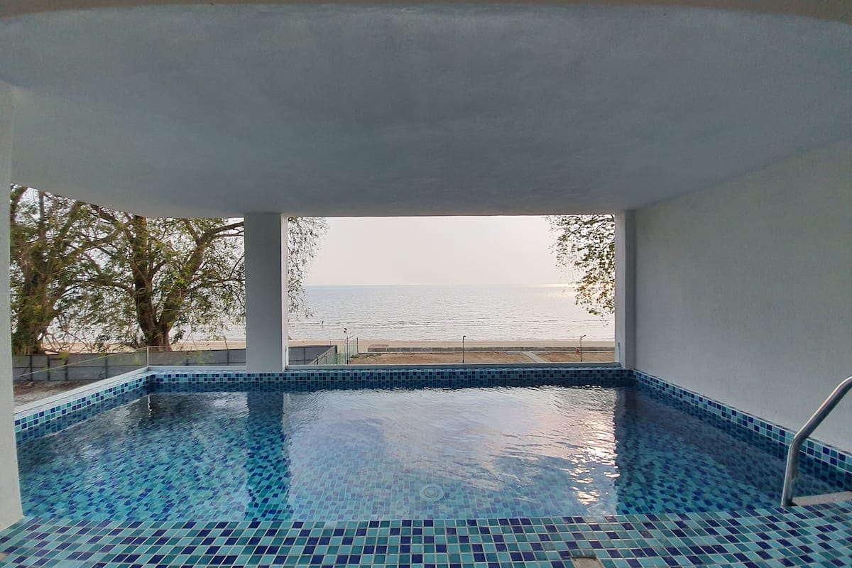 An indoor swimming pool with a view of the sea.