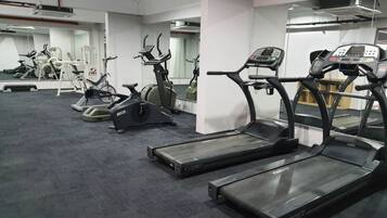 A gym with treadmills, stationary bikes, and elliptical machines.