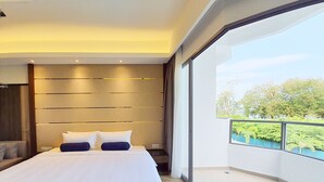 Ein modernes Schlafzimmer mit einem großen Bett und Blick auf Grün durch einen Balkon, im zeitgenössischen Design.