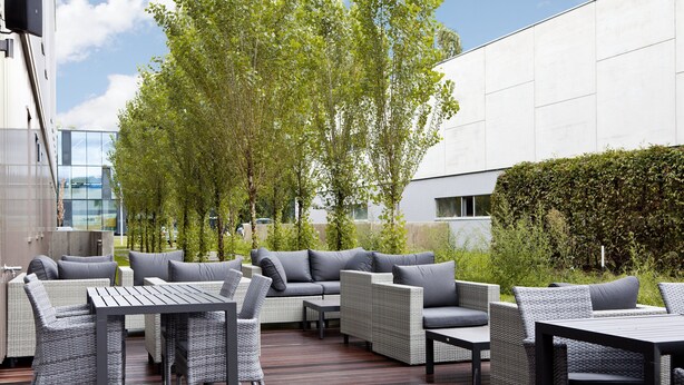 An outdoor patio area with wicker furniture and a wooden deck.