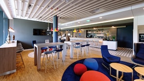 A modern interior with a bar area, seating arrangements, and a wooden ceiling.