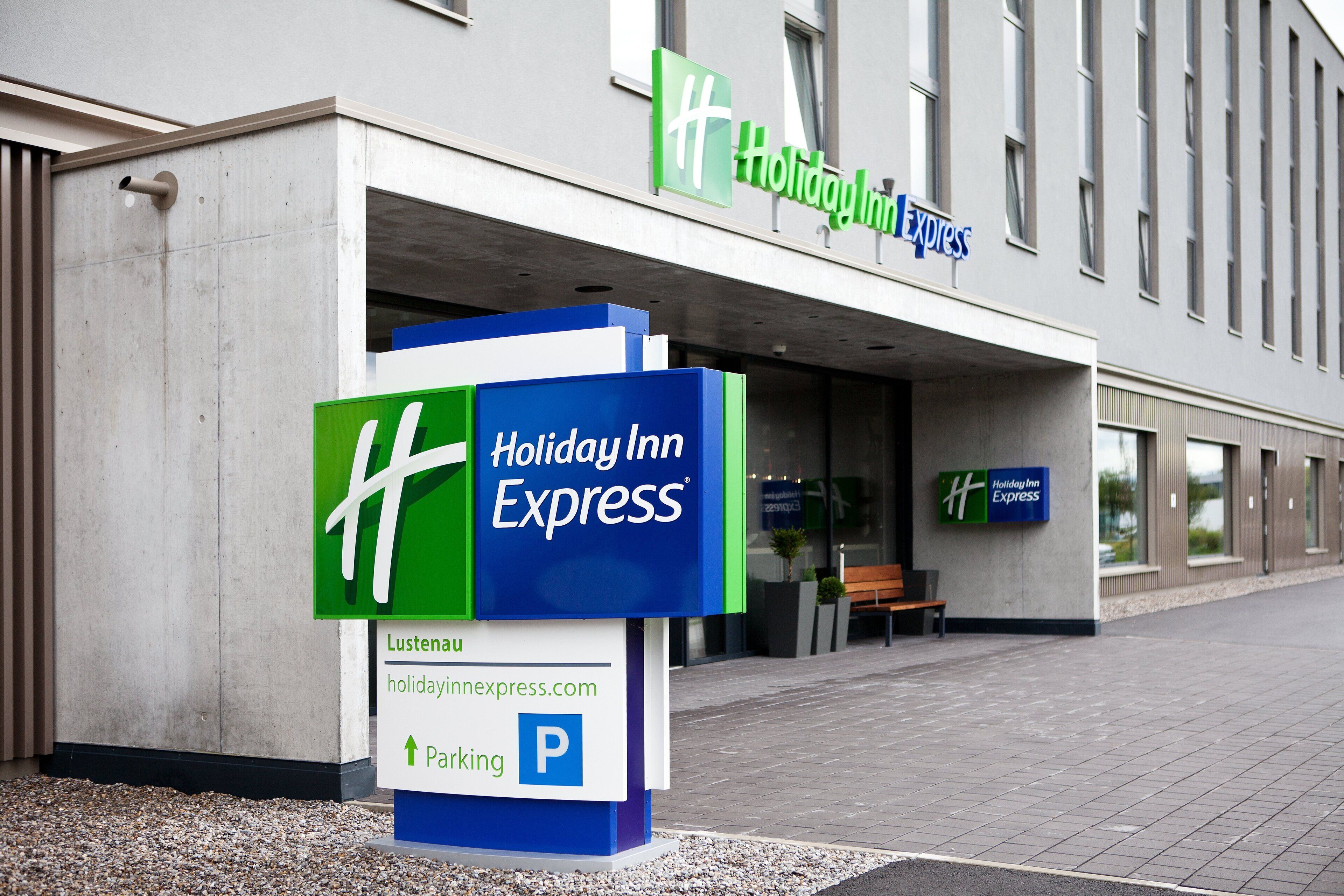 Een Holiday Inn Express gebouw met een opvallend bord en een parkeersbord.