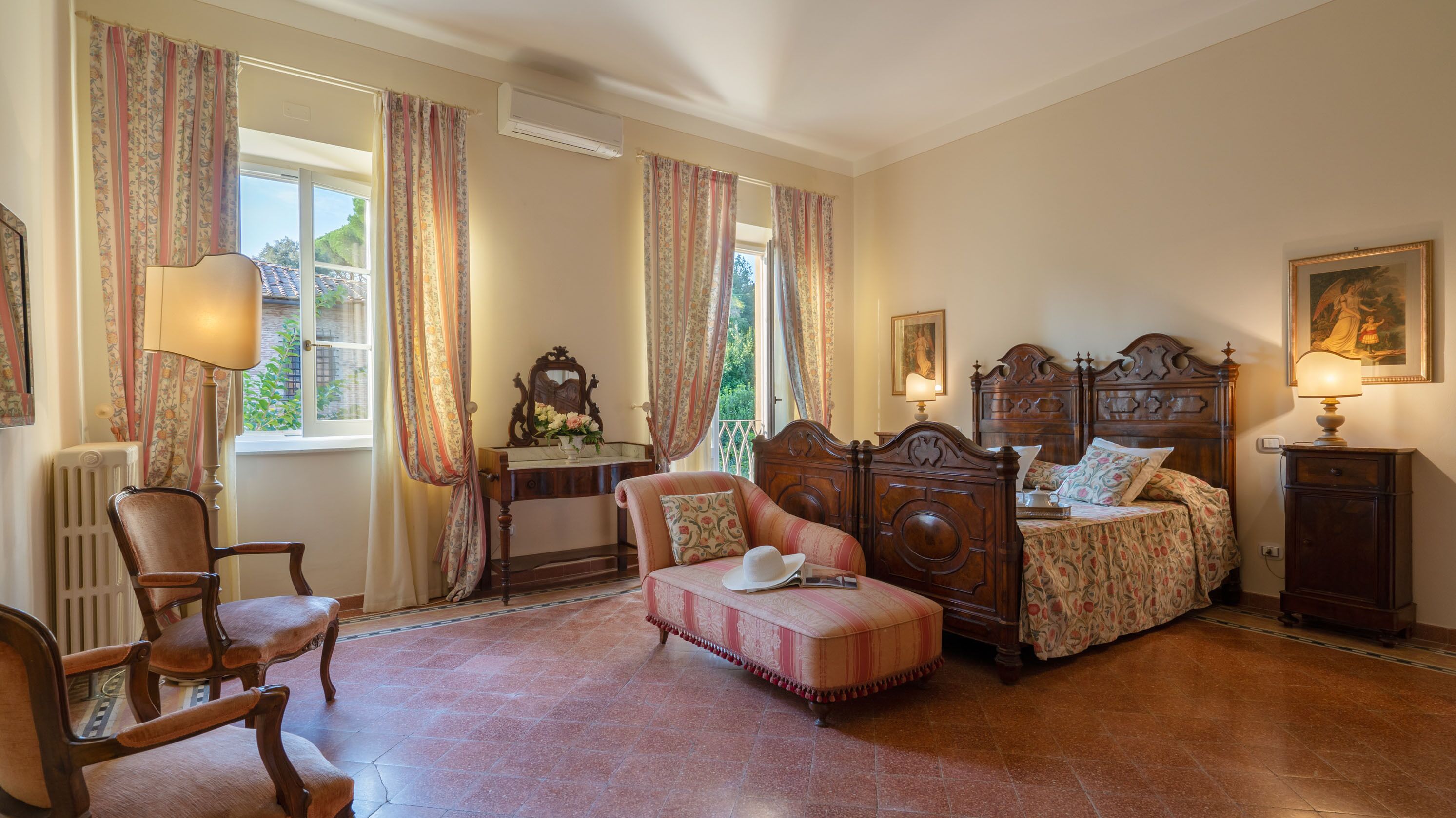A bedroom with a wooden bed, a chair, a small table, and a radiator.