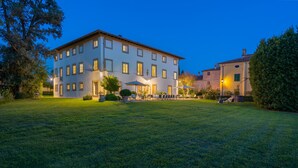A large, multi-story building with a well-maintained lawn in front. - Tenuta Di Pratello 24, Emma Villas (Peccioli)