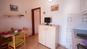Cocina compacta con comedor, un mueble empotrado y un estante pequeño.