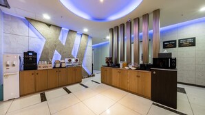 A modern kitchen with a central island, built-in appliances, and a unique geometric wall design. - Golden Business Hotel (Seosan)