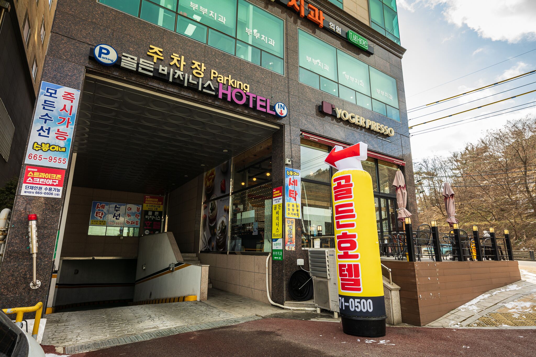 A hotel entrance with a sign for a parking garage and a coffee shop.