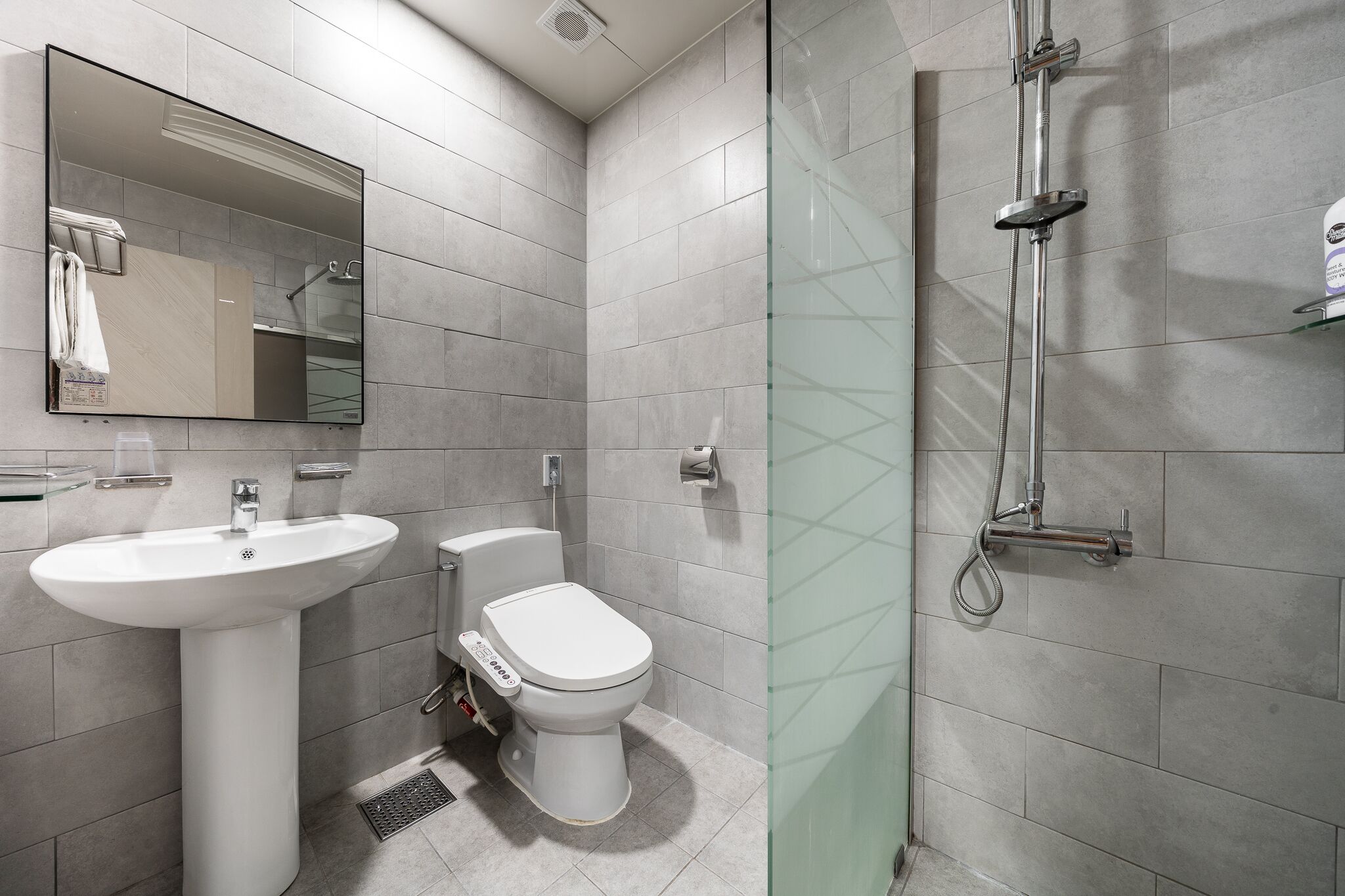 A modern bathroom with a sink, toilet, and glass-enclosed shower.