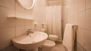 A bathroom with a sink, toilet, and shower curtain. - Residence La Valdana - 3 room apartment with swimming pool, tennis and parking 1km from the beach (Capoliveri)